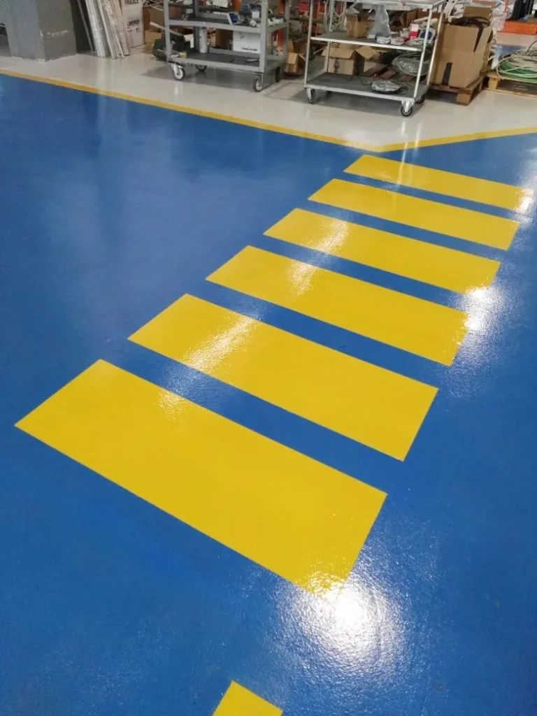 Pavimentazione in resina blu con attraversamenti pedonali gialli